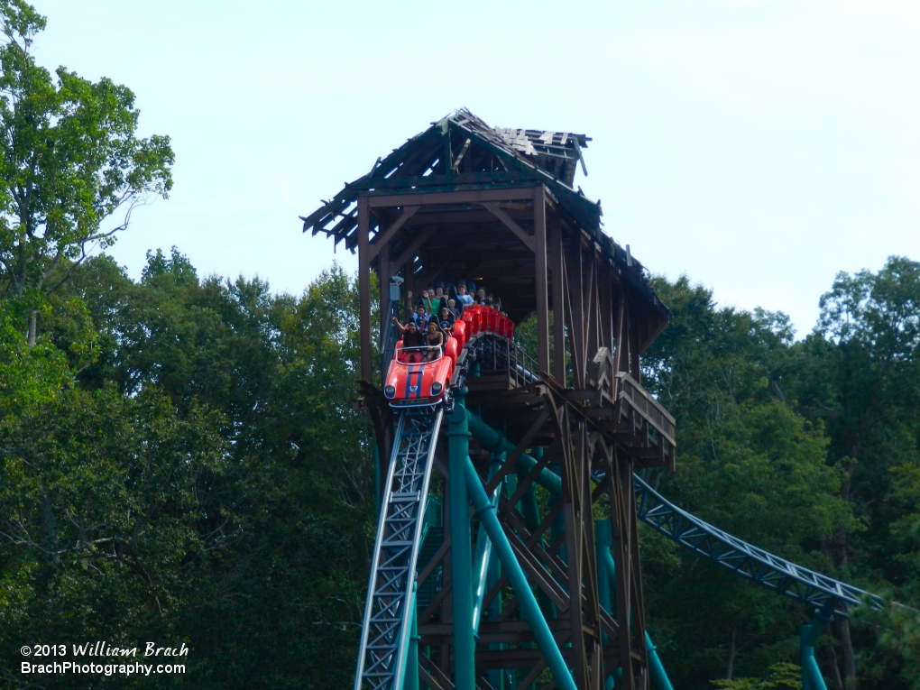 Red train falling out of the broken bridge.