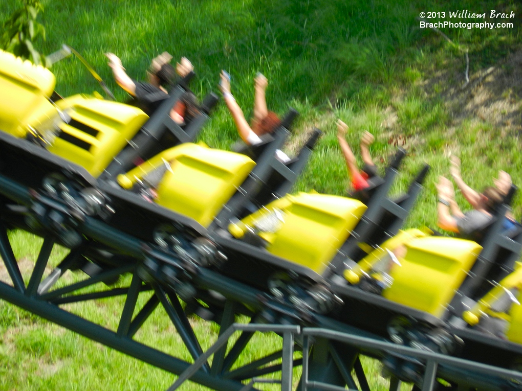 Yellow train moving fast out of the forest!