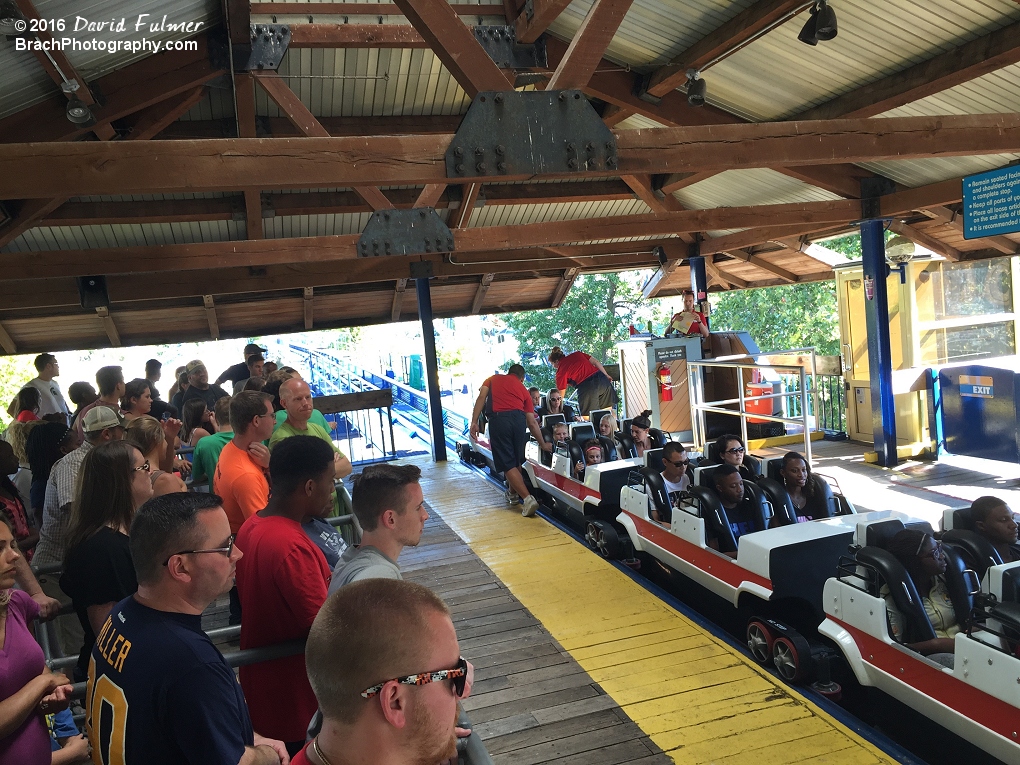 Looking inside Corkscrew's station as the Corkscrew team checks restraints on the white train.