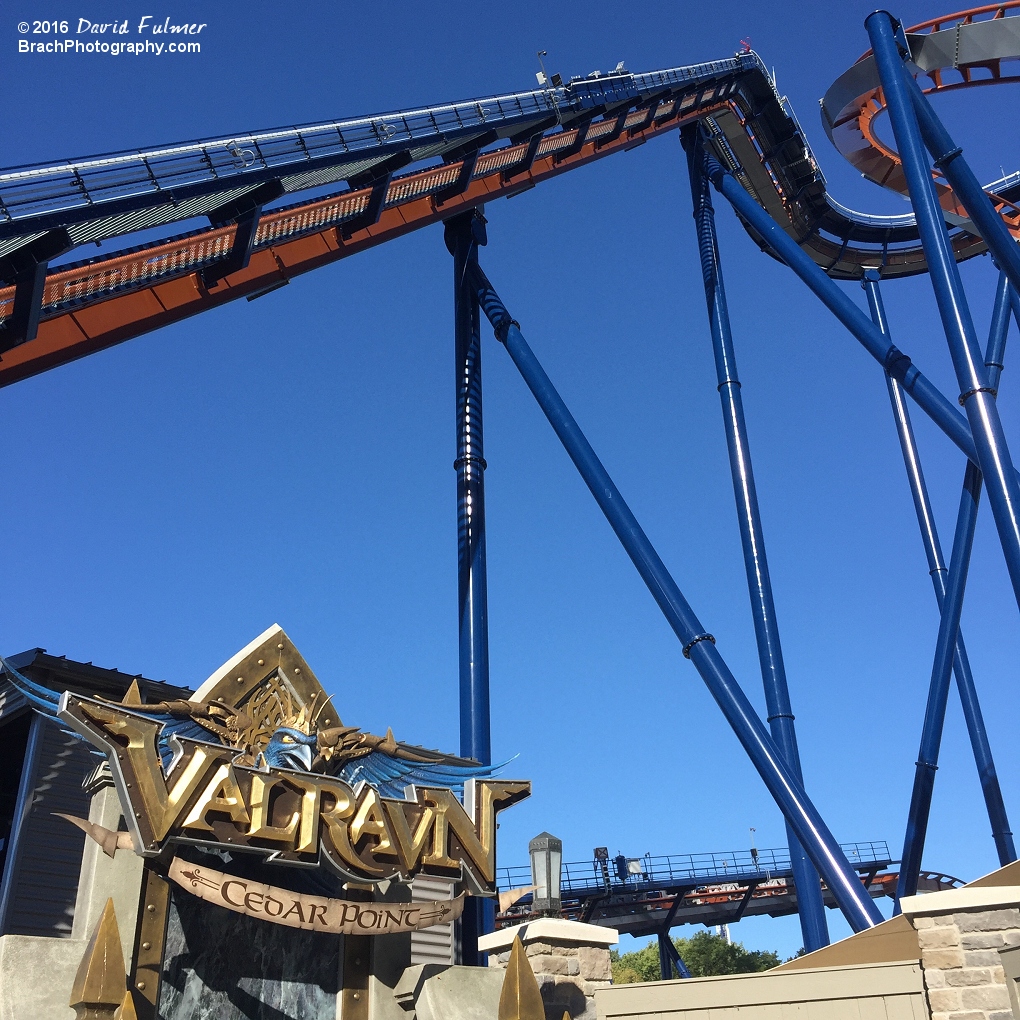 Train at the top of the lift hill and sculpture of sign.