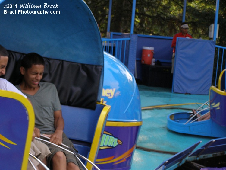 Riders getting tossed around in their Tilt-a-Whirl cabin.