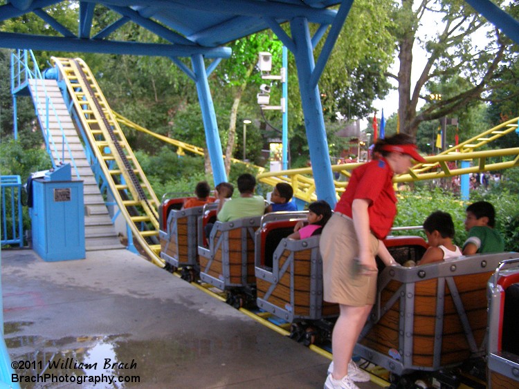 Woodstock Express station.  Ride op checking the restraints.