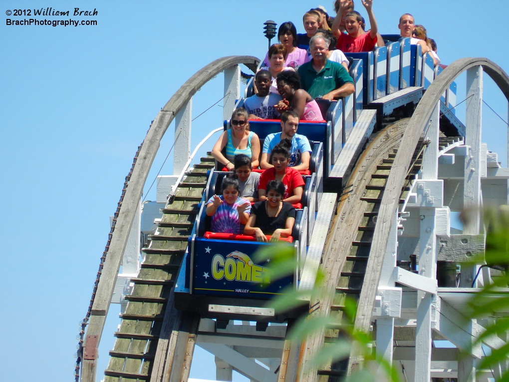 Closeup view of a train full of riders about to go down the first drop on Comet.