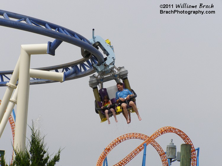 Riders riding Roller Soaker about to return to the station prepare to drop their loads of water on unsuspecting guests in the line for the ride.