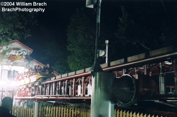 View of the launch track at night.  Those fins on the track are actually brake fins that get lowered into the track to allow the train to launch.  As soon as the train has launched, those fins come right back up to stop the train if it were to fail clearing the top hat.