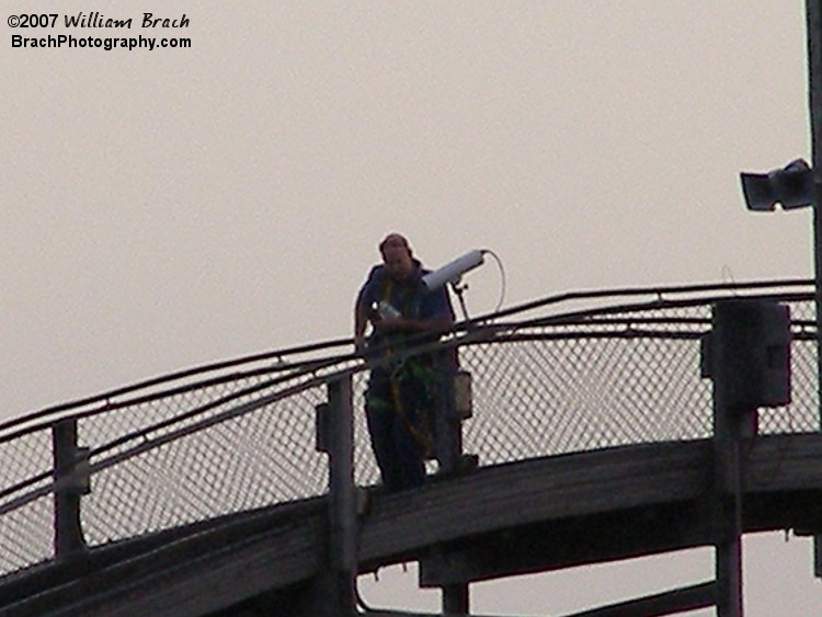 Kings Dominion coaster maintenance guy checking something on the lift hill.