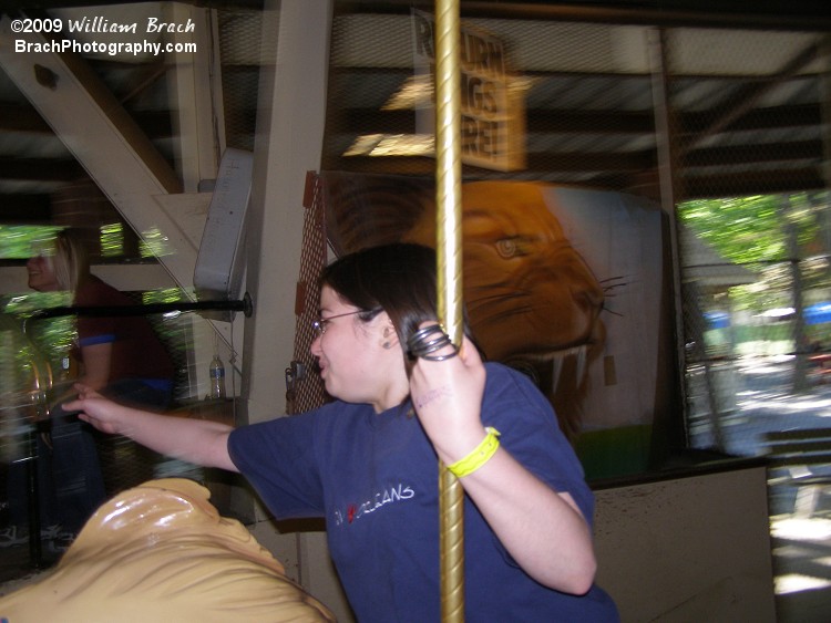 Laura reaching for another ring to add to her collection.  In the background is the lion's mouth that's used as the target that riders would throw their collected rings towards at the end of the ride.