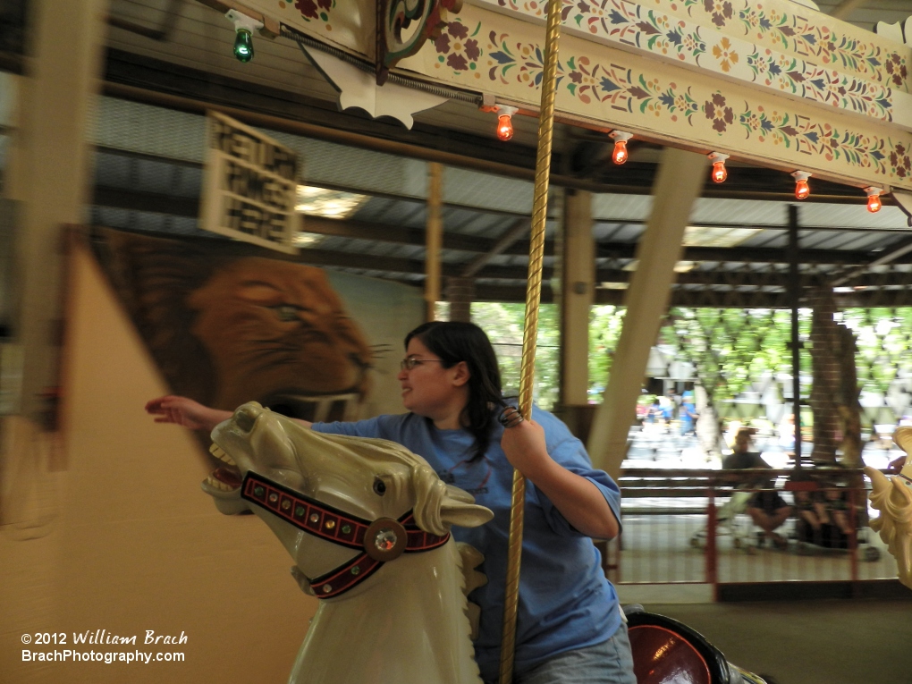 Staff Photographer Laura reaching for her next ring on the Grand Carousel.