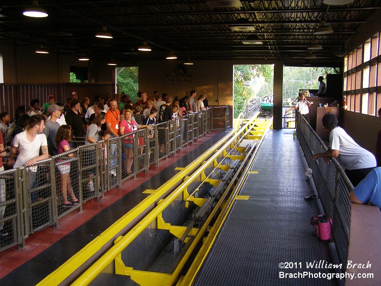 Train waiting to enter the station full of riders.