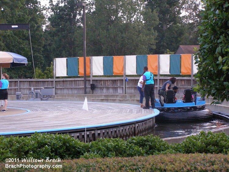 Roman Rapids uses a rotating platform to unload/load the boats.  This helps with speeding up the queue line which does tend to get quite long on those very hot summer days.