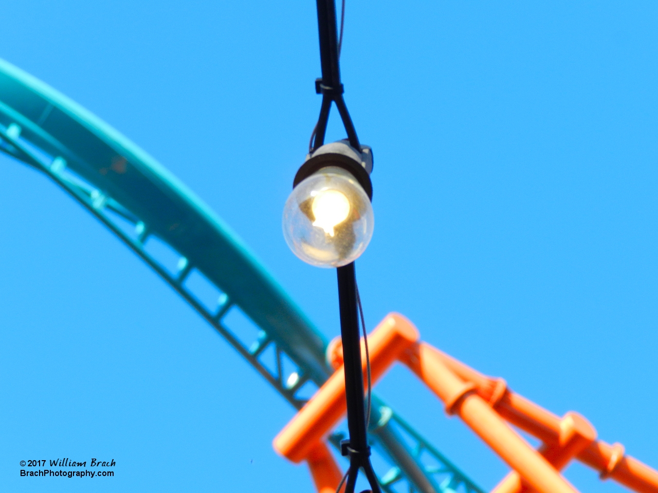 A traveling carney styled light bulb with Tempesto in the background.