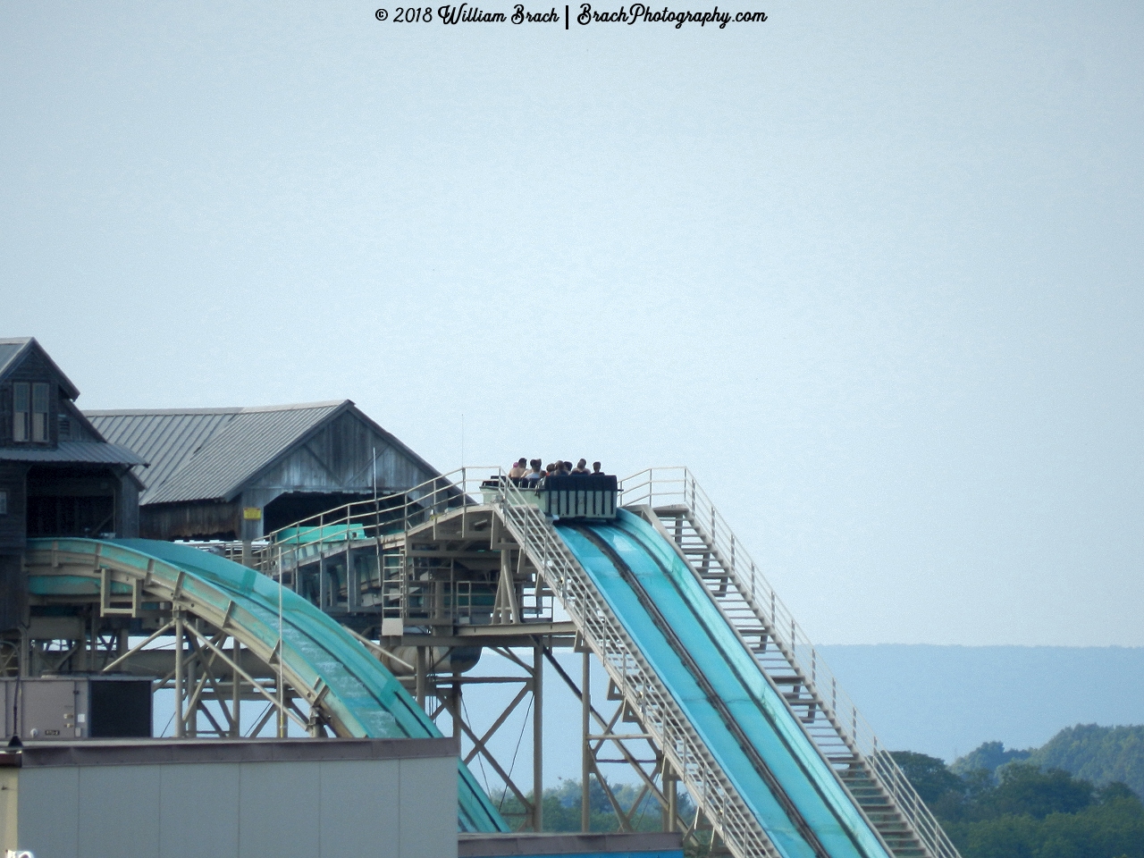 A boat on the White Water Landing spill water ride cresting the top of the lift hill.