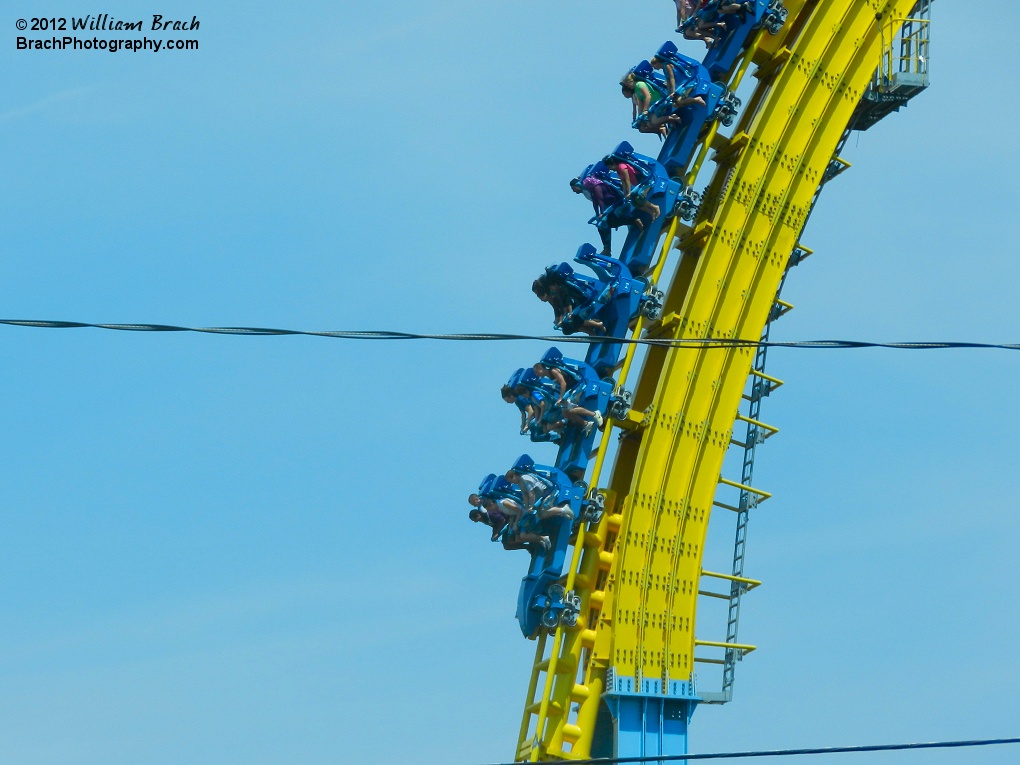 Another train loaded with riders making their way down the first drop on Skyrush.