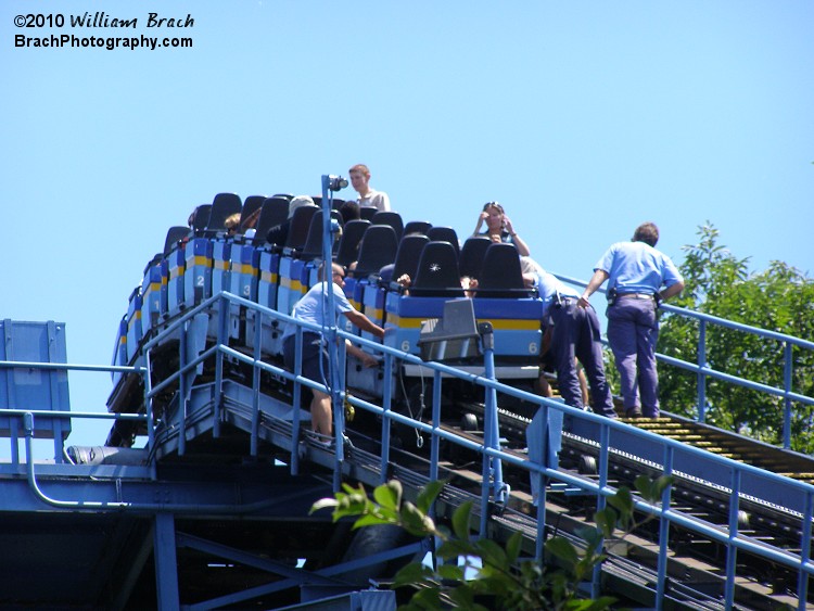 Hersheypark maintenance guys are releasing the lap bars to allow the riders to walk down the stairs on the lift hill.