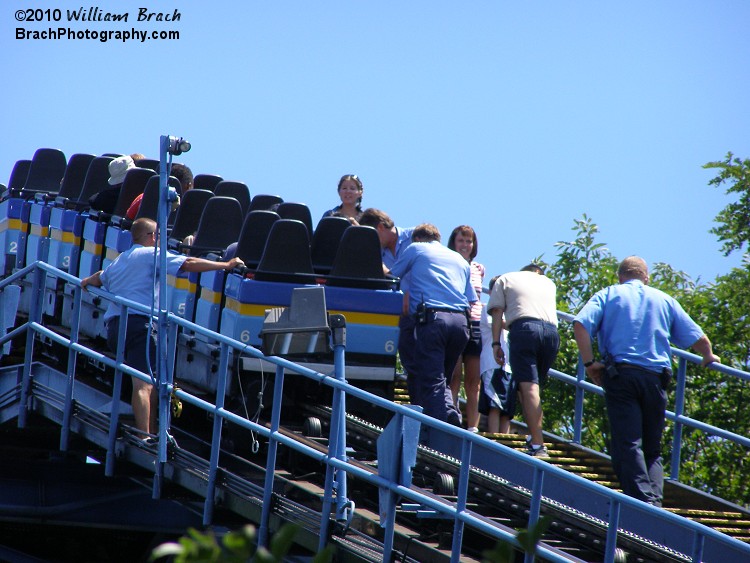 SooperDooperLooper riders are getting out of the train stopped on the lift hill.