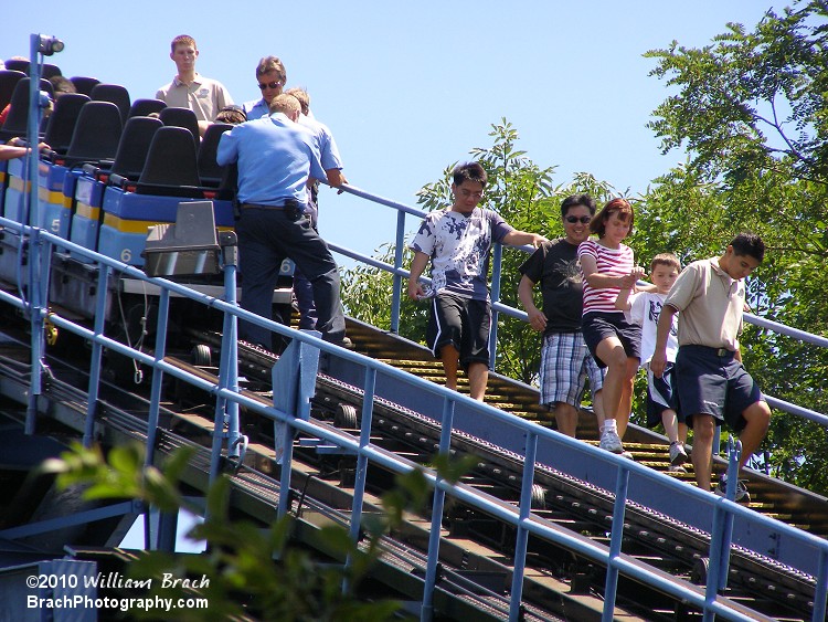 Riders are seen climbing down the lift hill stairs.  SooperDooperLooper did reopen later on that day.