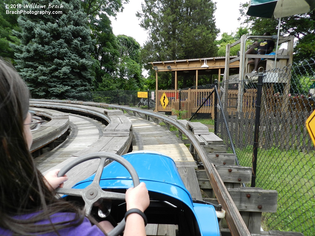 Going bast the watch tower in a blue car.