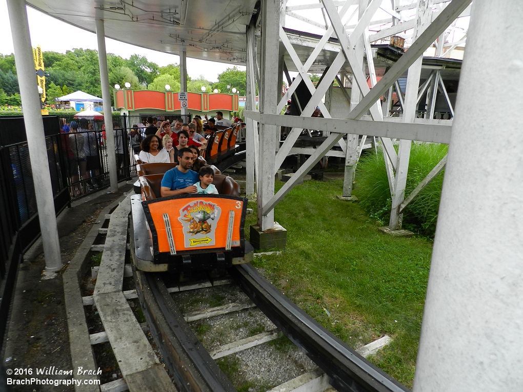 Orange train departing the station and headed towards the first drop into the ravine.