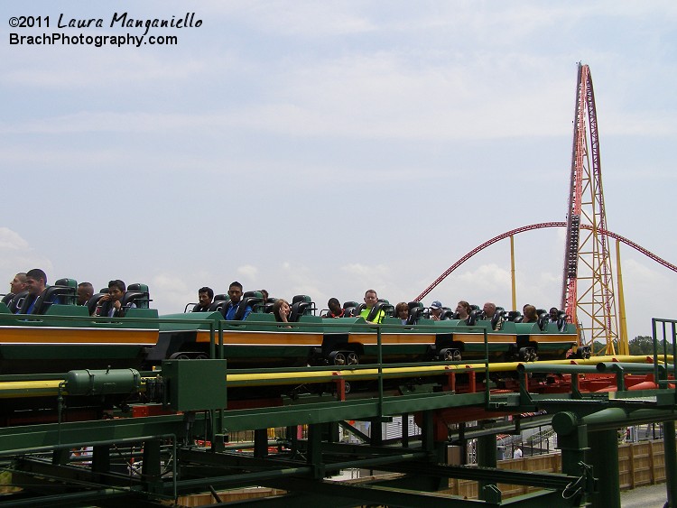 Anaconda train sits on the brake run while the other train is in the station loading up.  An Intimidator 305 train is seen making its way up the lift hill in the background.