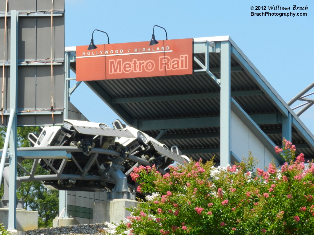 White train on Backlot Stunt Coaster headed down the "stairs" into the rail station.