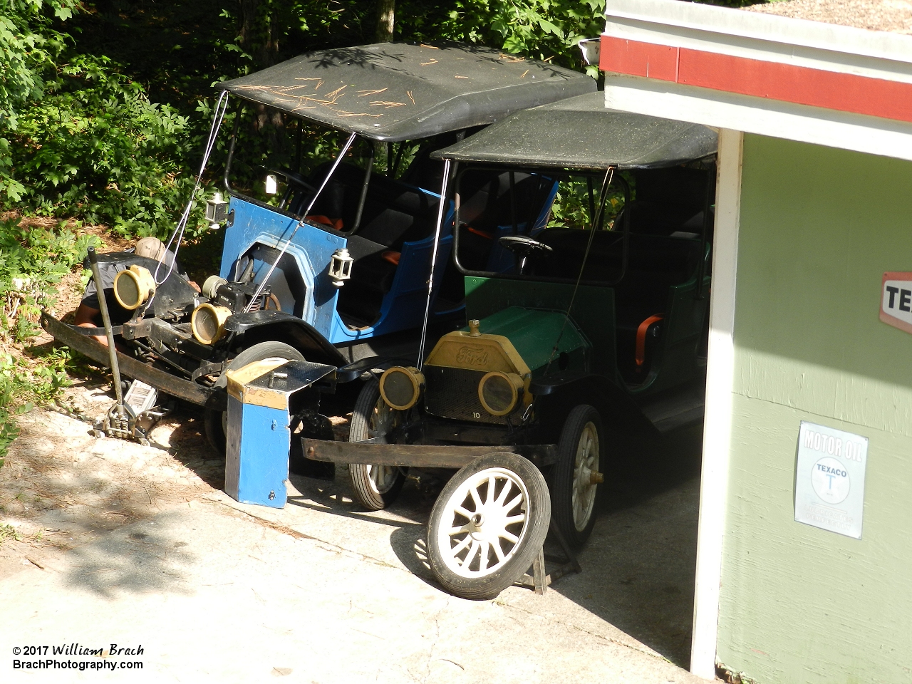 Blue and green Tollway cars in the shop getting worked on.