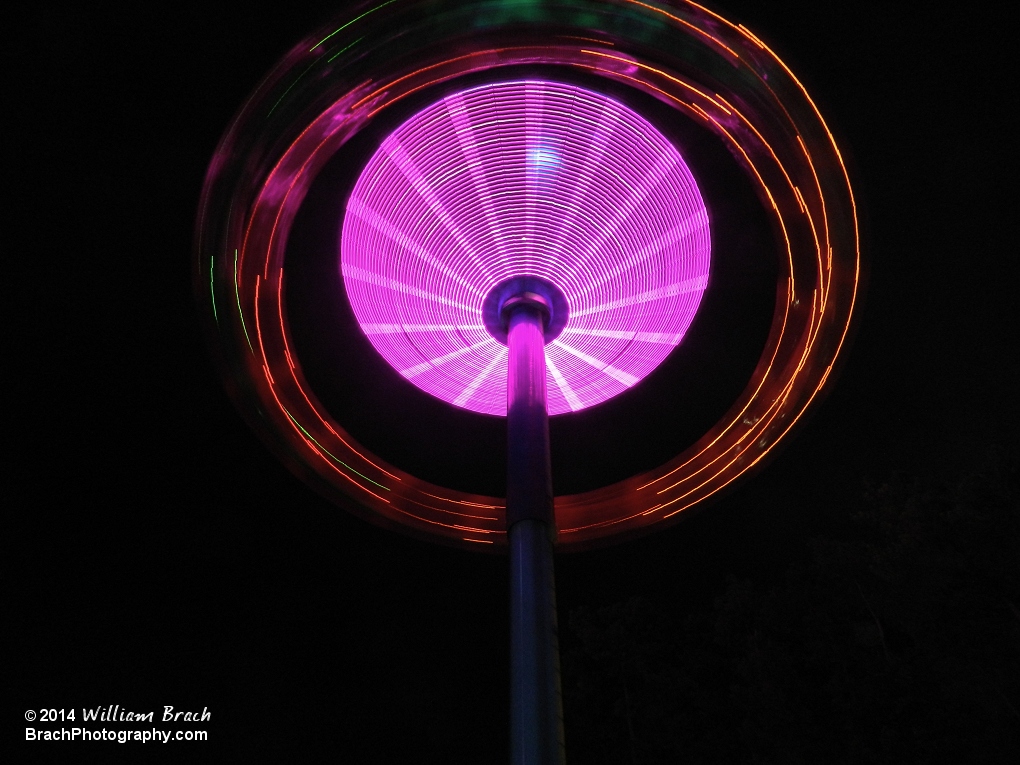 Looking up at the ride in motion at night.