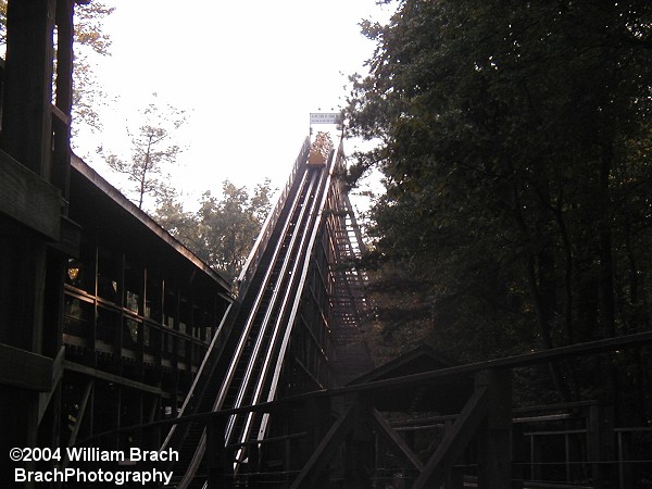 The yellow train is cresting the lift hill here.