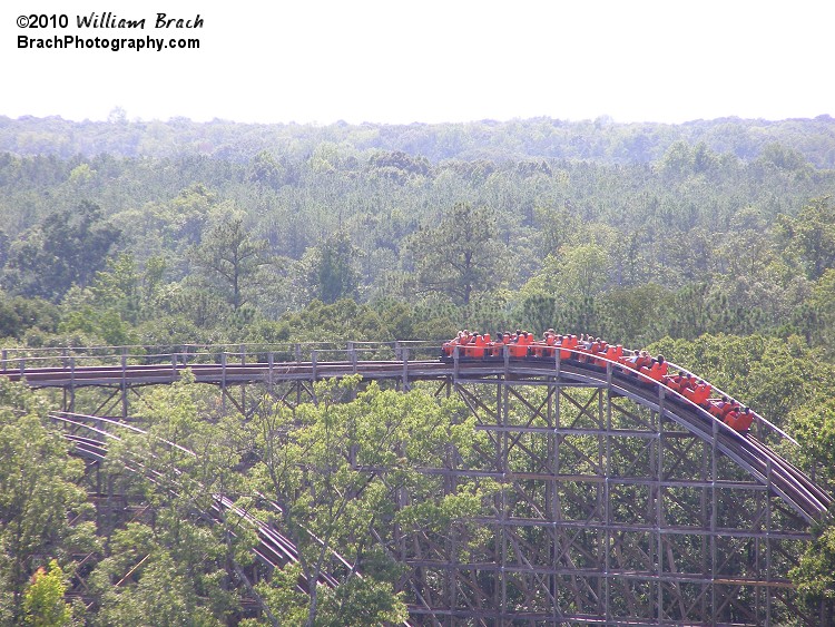 Orange train has just crested the second hill and is about to enter the turn towards the second drop.