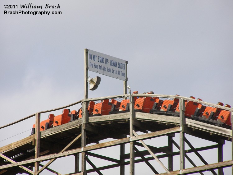 Orange train climbing over the lift hill.