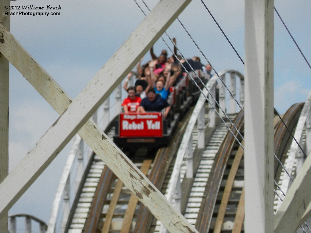 A red Rebel Yell train seen through the wooden lumber of the coaster.