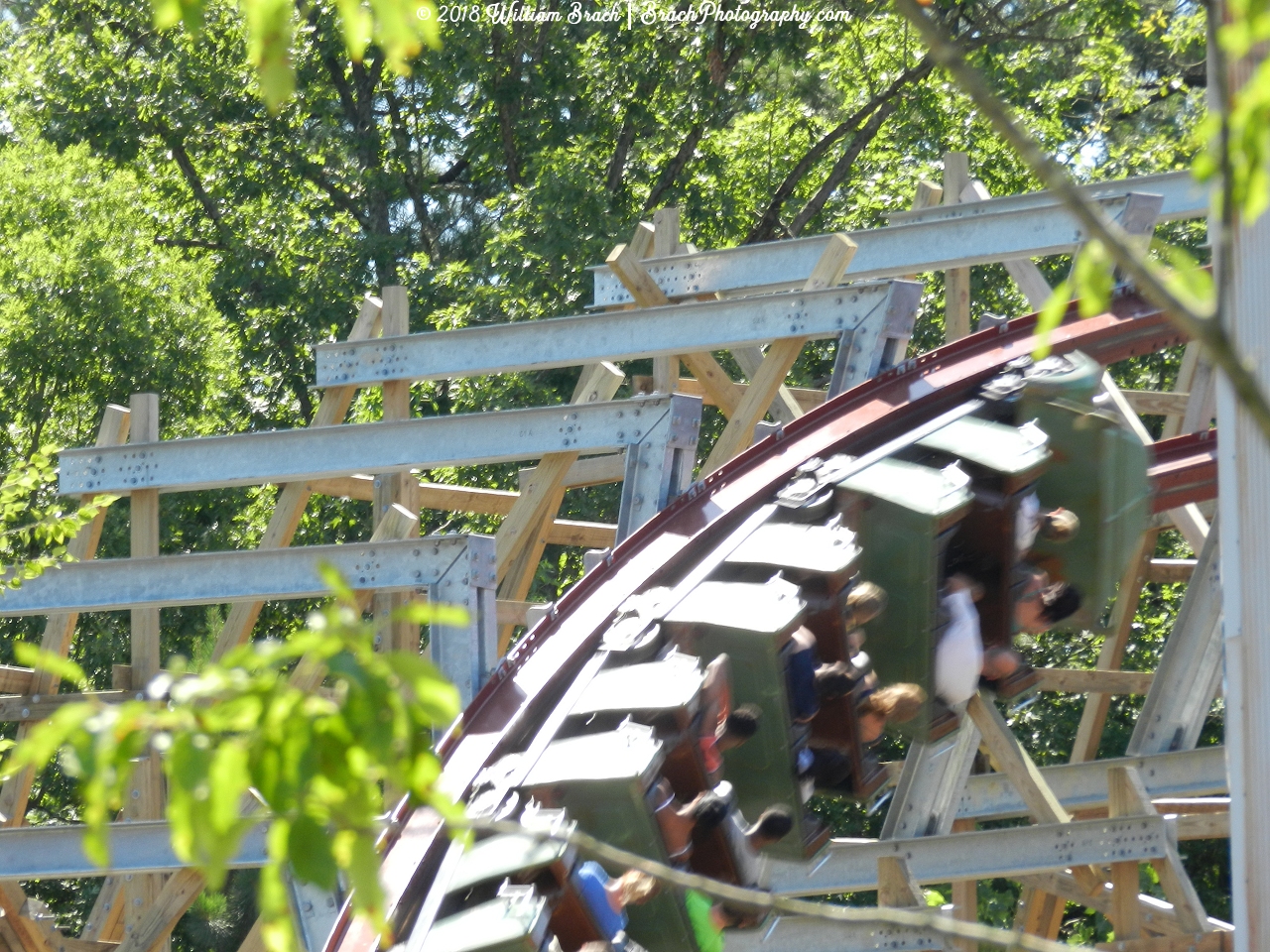 Twisted Timbers green train going through the overbanked turn.