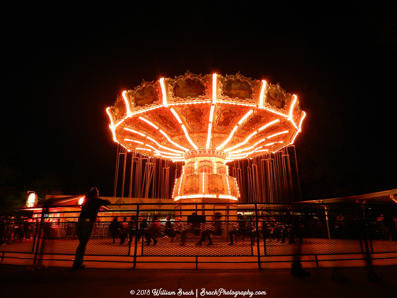 Red and White lights illuminating the Wave Swinger at night during Halloween Haunt.