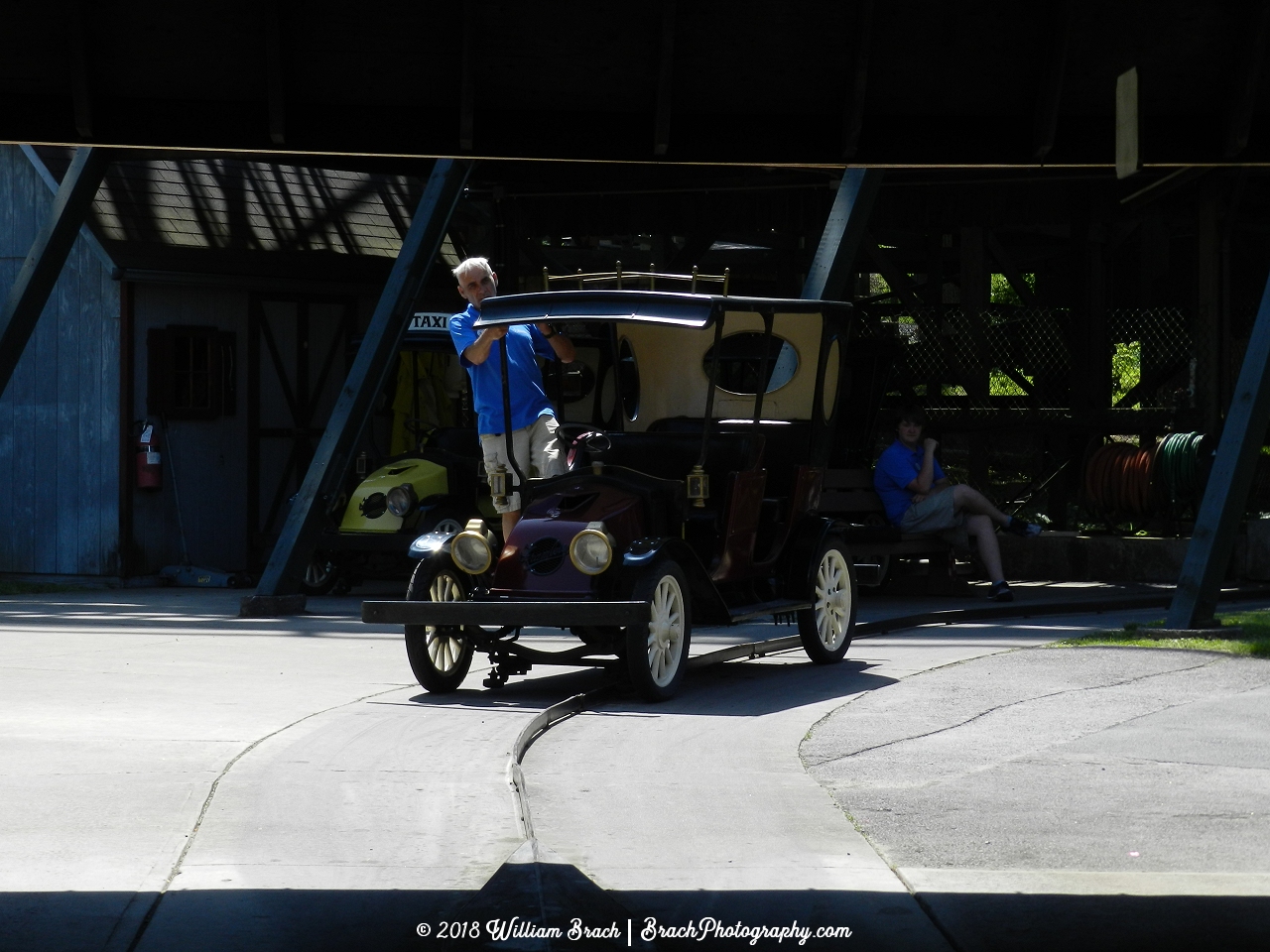 A ride operator moving the Gasoline Alley car to the station for the next riders.