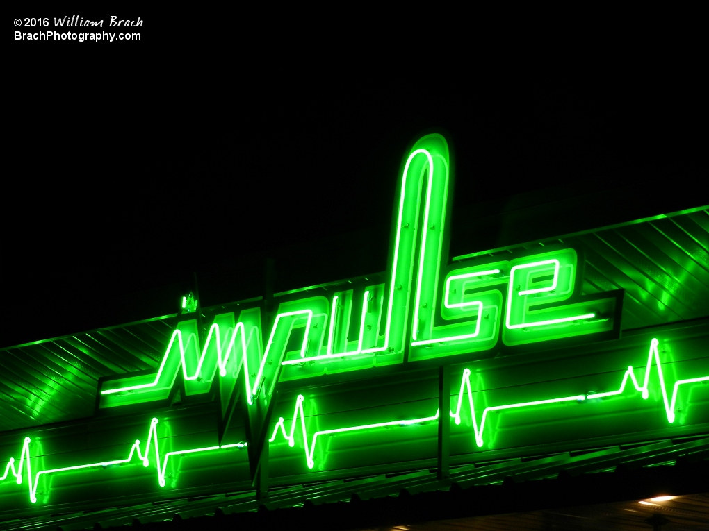 Impulse sign all lit up in green lights at night.