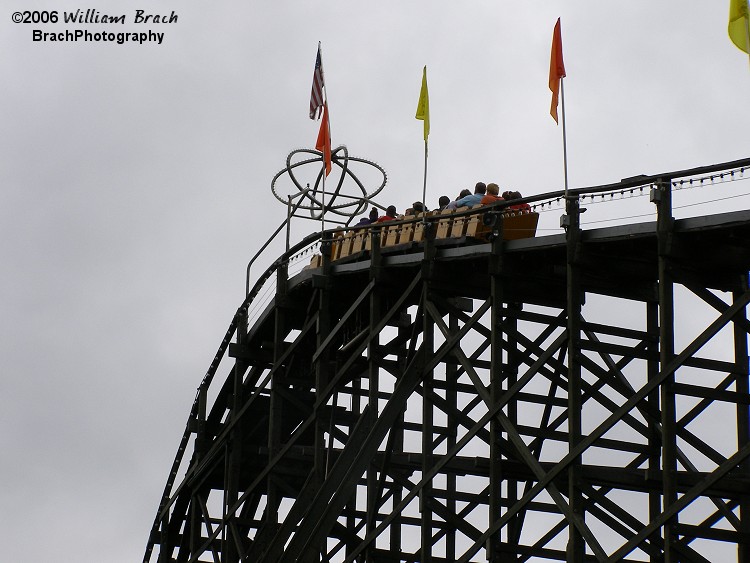 Yellow train getting close to the top of the lift hill.