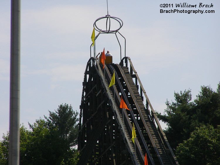 Yellow train going over the lift hill.