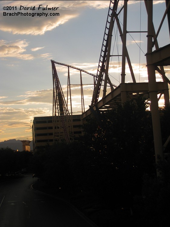 The train drops 2nd hill of the tracks in sunset.