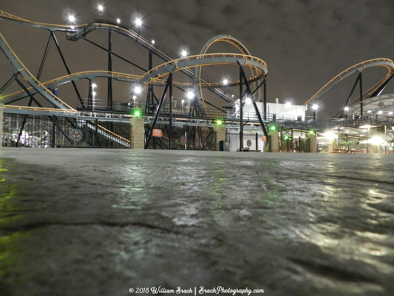 Apocalypse ride area at night with the green warning lights lit up.