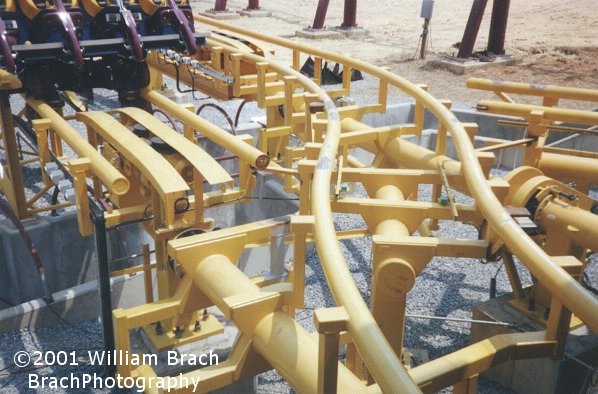 Rotating track to allow the dual load station to be fed into one single track.  The track joints would rotate to allow the track to line up correctly.