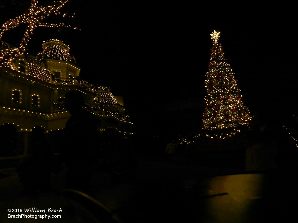 The tree and theater lit up in lights.