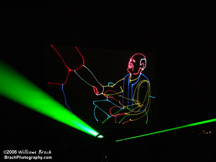 Sittin' on a bench, drawn by lasers, shaking the hand of another young lad.