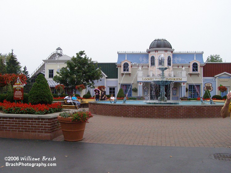 The Loony Tunes Emporium is behind the fountain.