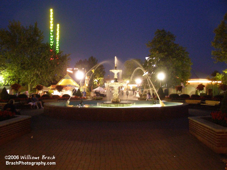 Fountain lit up at night, looking towards the front gates.