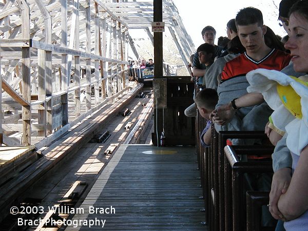 Riders wait for the black train to return to the station.