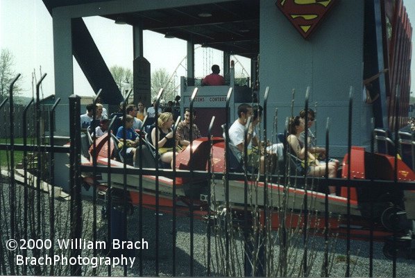 The red train departing the station heading towards the lift hill.