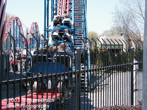 Looks like Superman: Ride of Steel was experiencing some problems on Opening Day 2003.  There's a ride op standing on the lift stairs to make sure all the riders are OK.