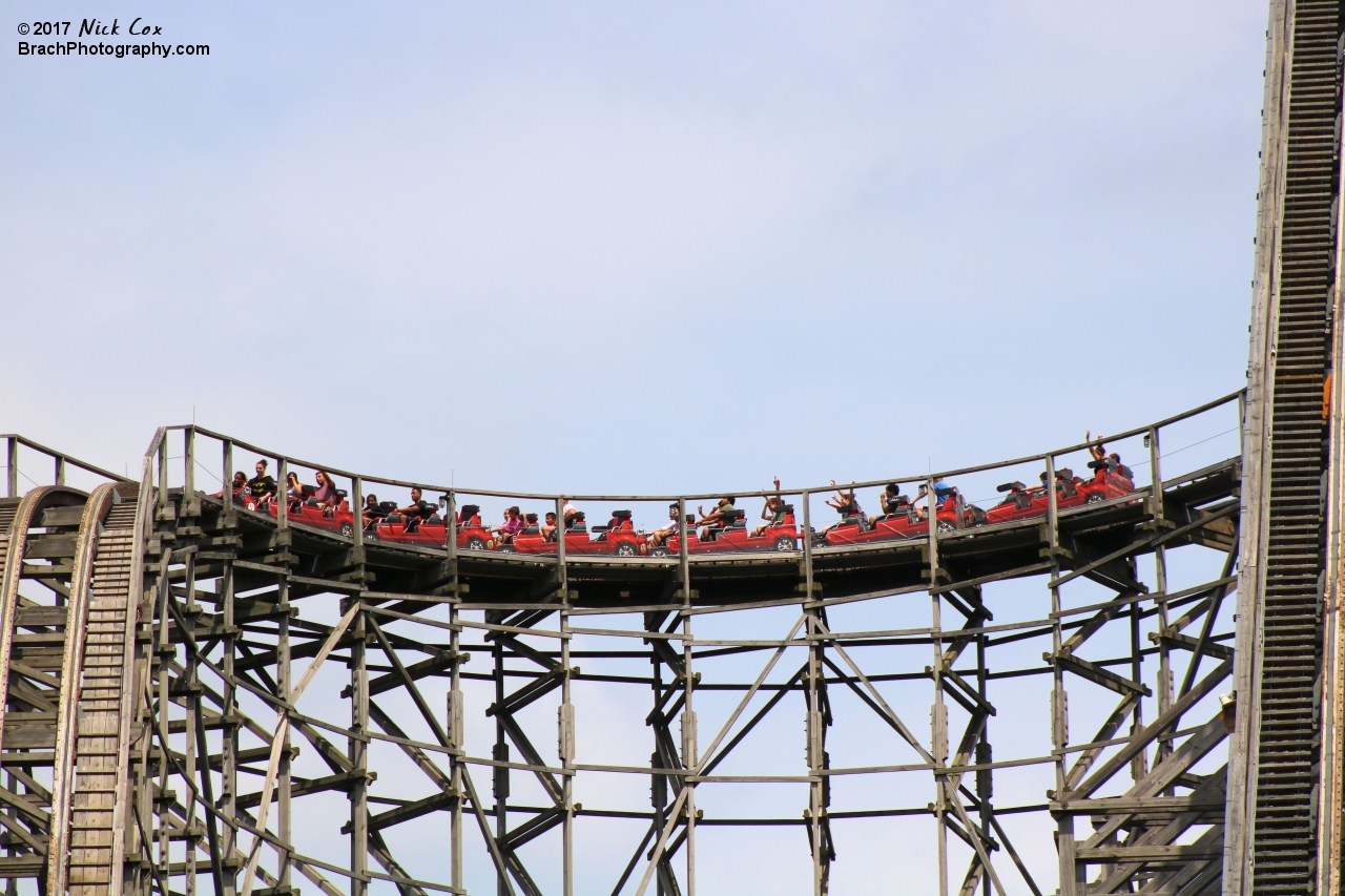 The train going around the curve at the top of the hill.