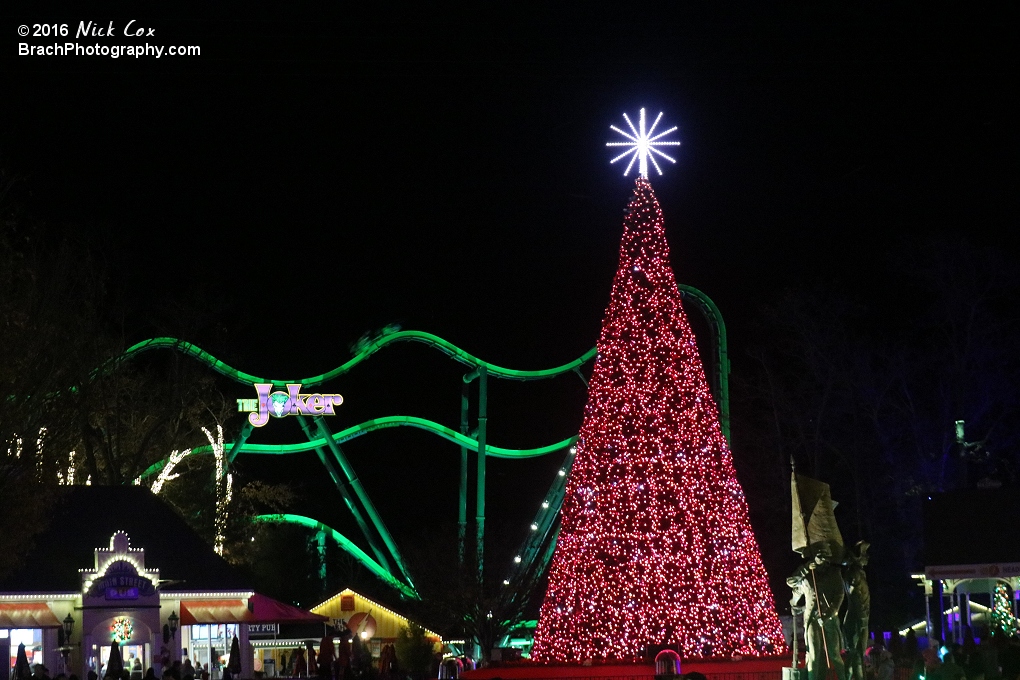 A Christmas tree with the Joker in the background.