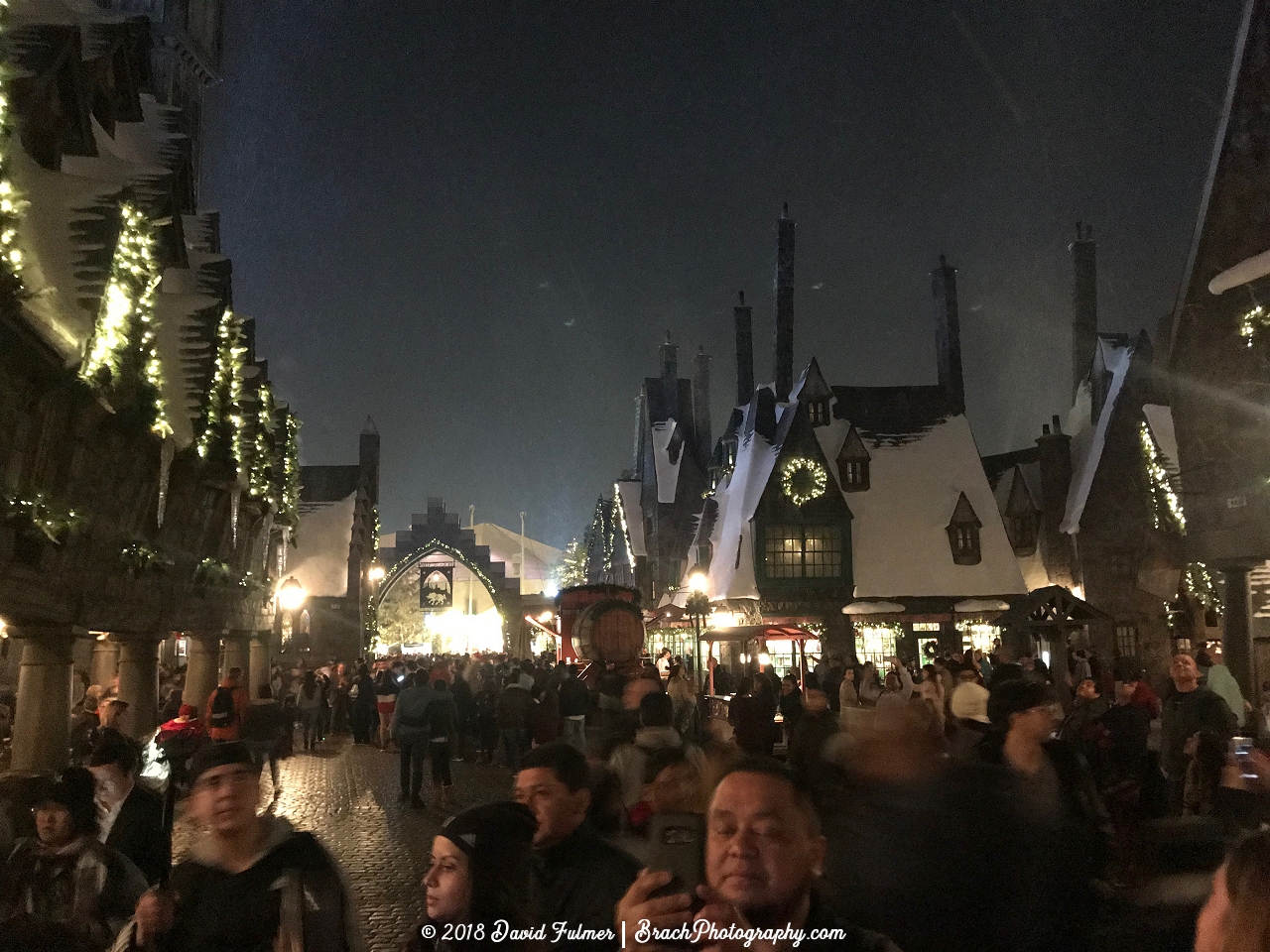 Hogsmeade area of the park all lit up at night.